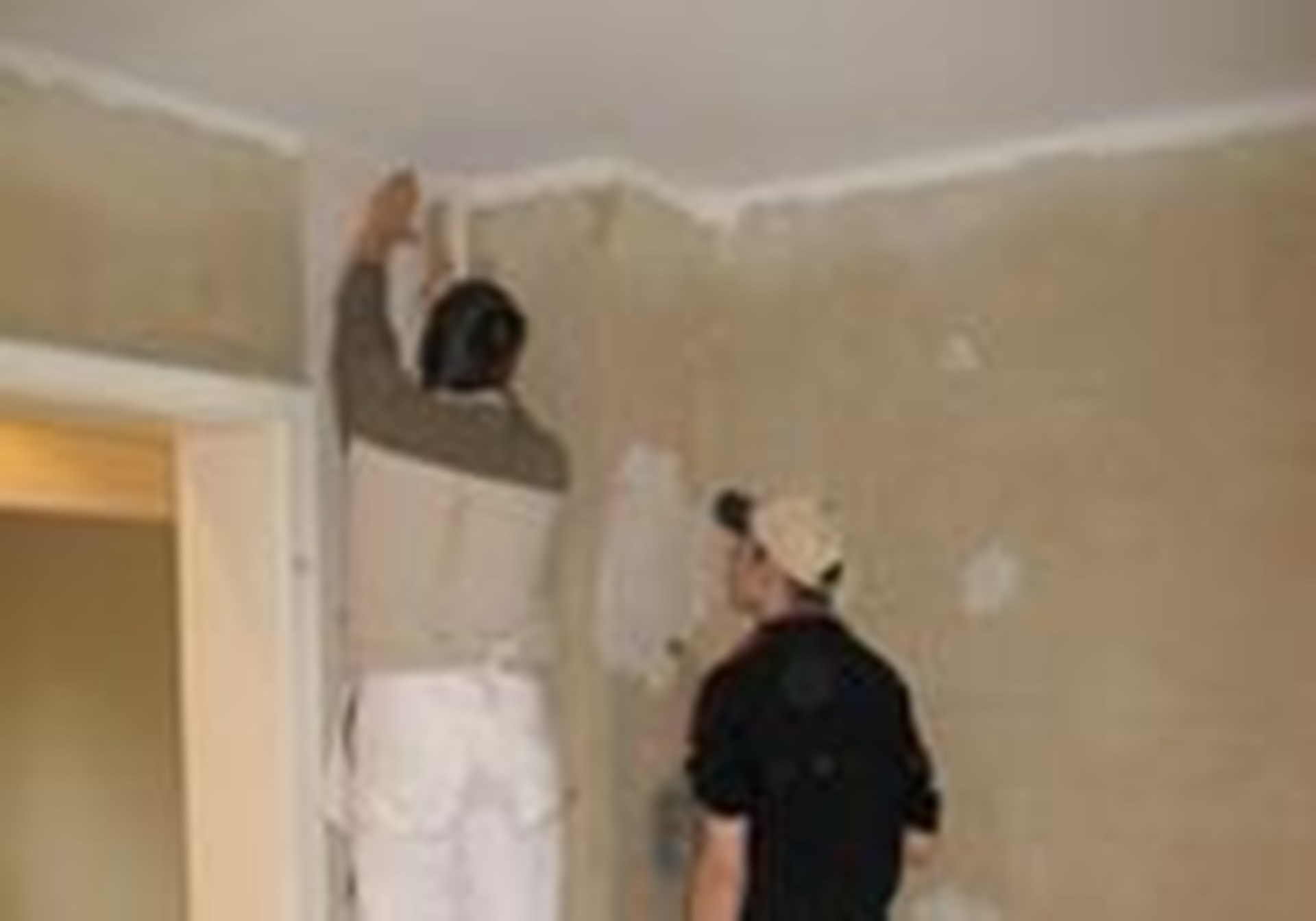 zwei Personen bei MAlerarbeiten im Innenraum