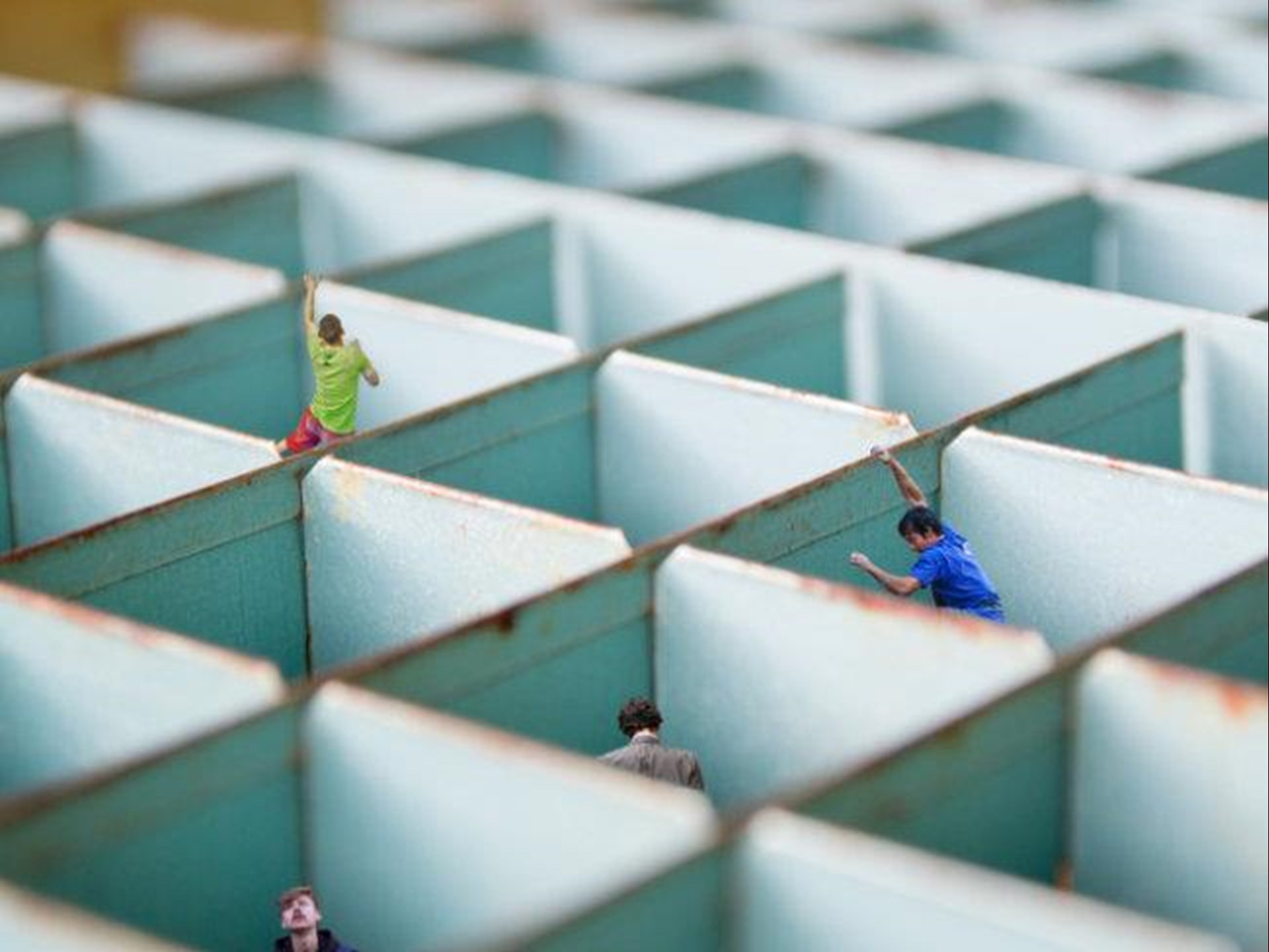 Mehrere Menschen gefangen in jeweils einer Box 
